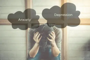 Person with head in hands, surrounded by anxiety and depression clouds.