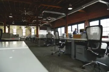 Open-plan office with desks, chairs, and large windows at D'Amore Mental Health.