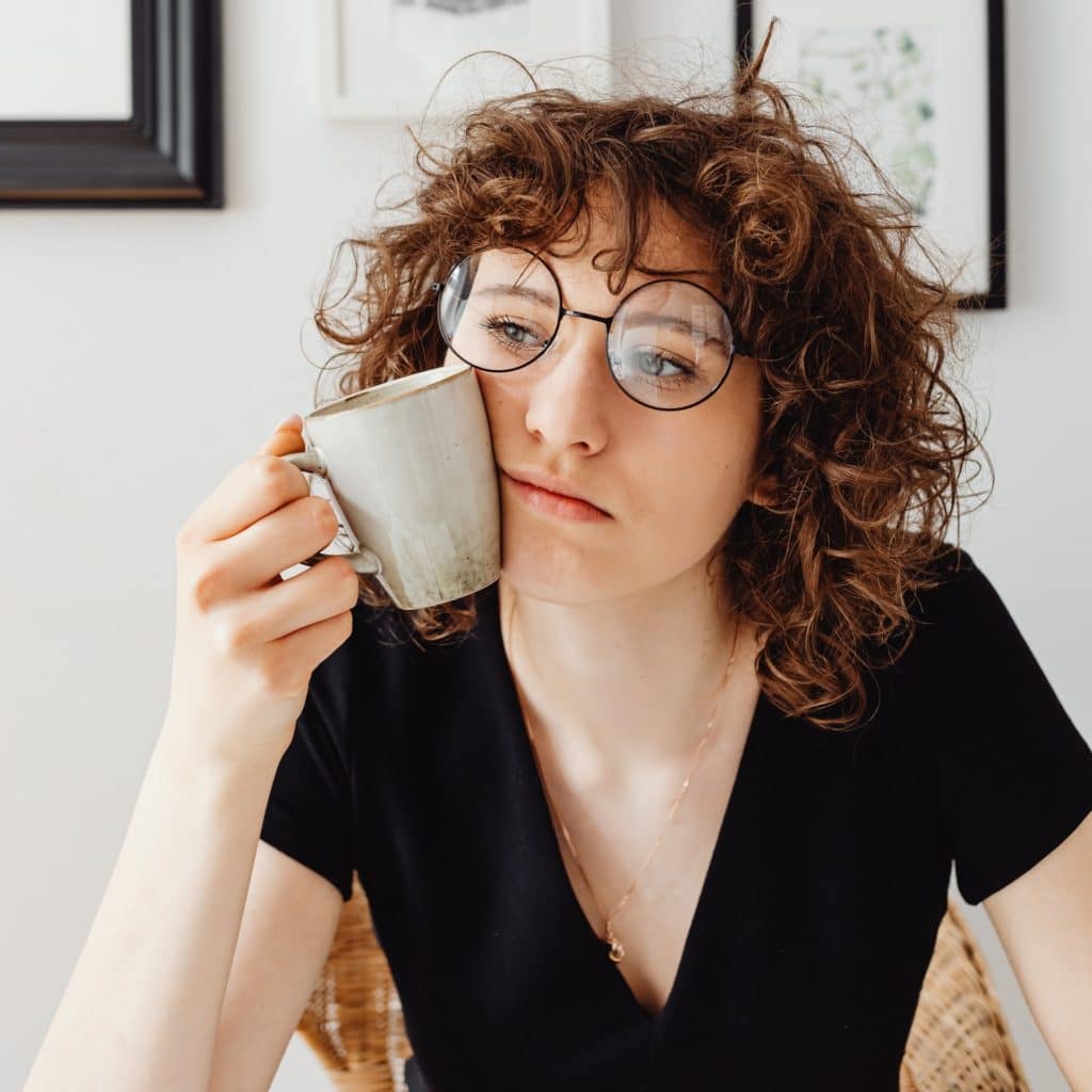 woman with coffee cup looking tired