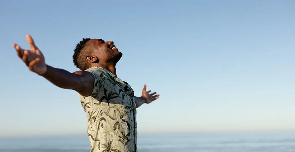happy man walking on the beach with arms outstretched