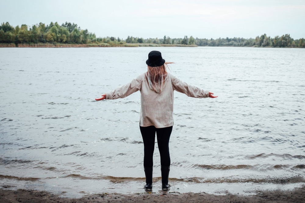 woman standing by a lake