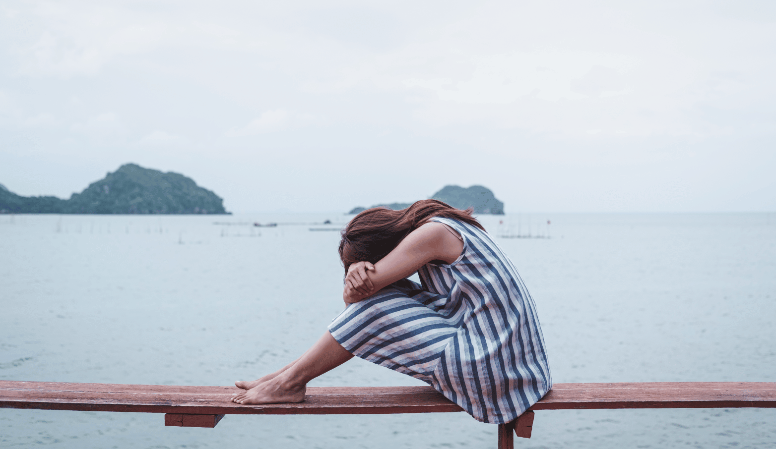 depressed young woman by sea side