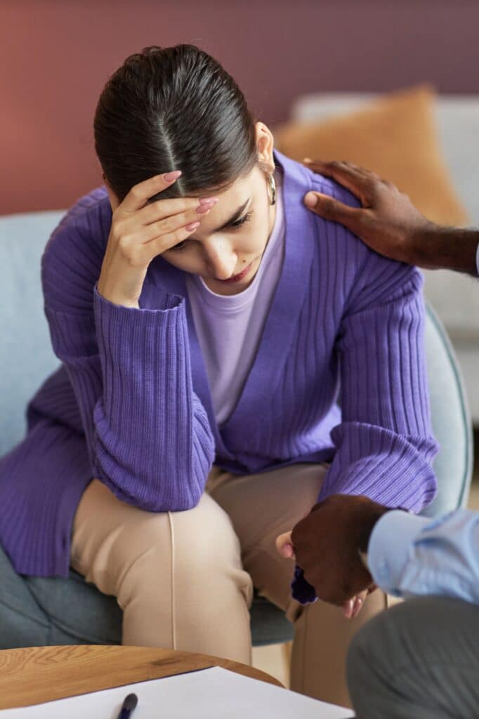 Therapist reassuring depressed young woman