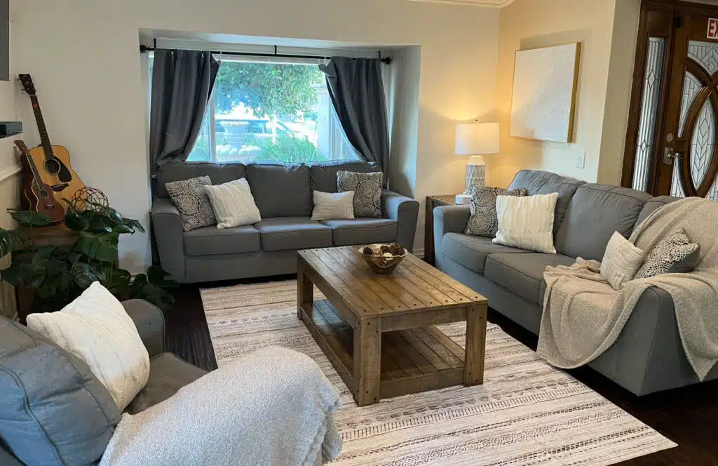 Cozy living room with sofas, coffee table, and natural light for mental wellness.