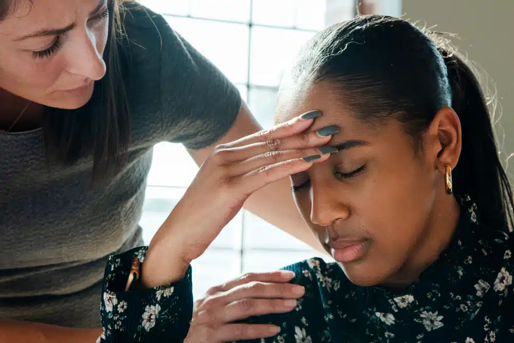 woman looking unnerved being comforted by a clinician