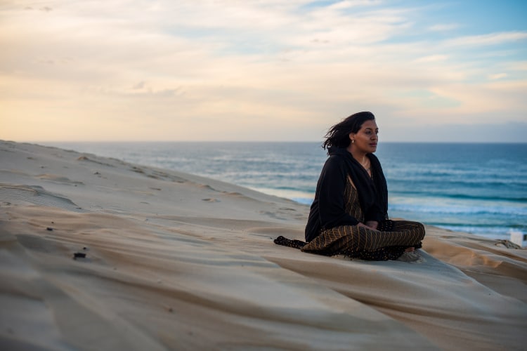 Woman meditating at the beach