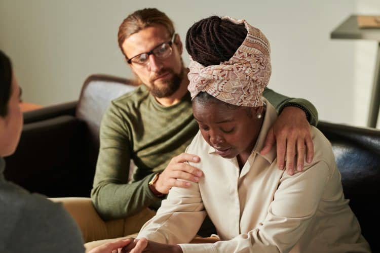 grieving couple talking to psychologist at office