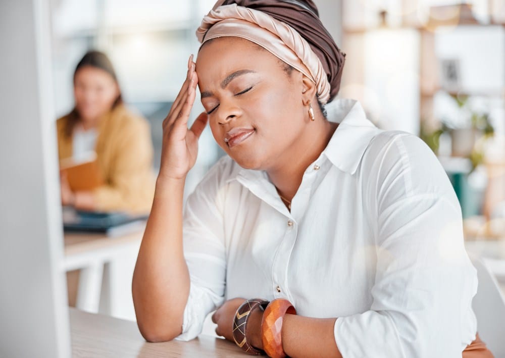 woman exhausted and overwhelmed with workload in office.