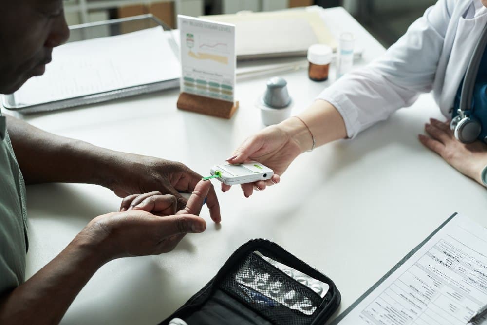 Man Getting Blood Glucose Test during Diabetes Consultation