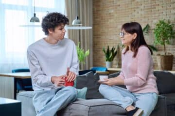 mother and son talking together in living room.