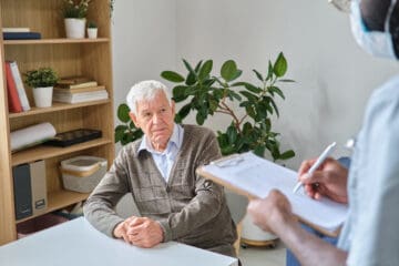 An elderly man sitting at a desk while asking a doctor does ocd get worse with age.