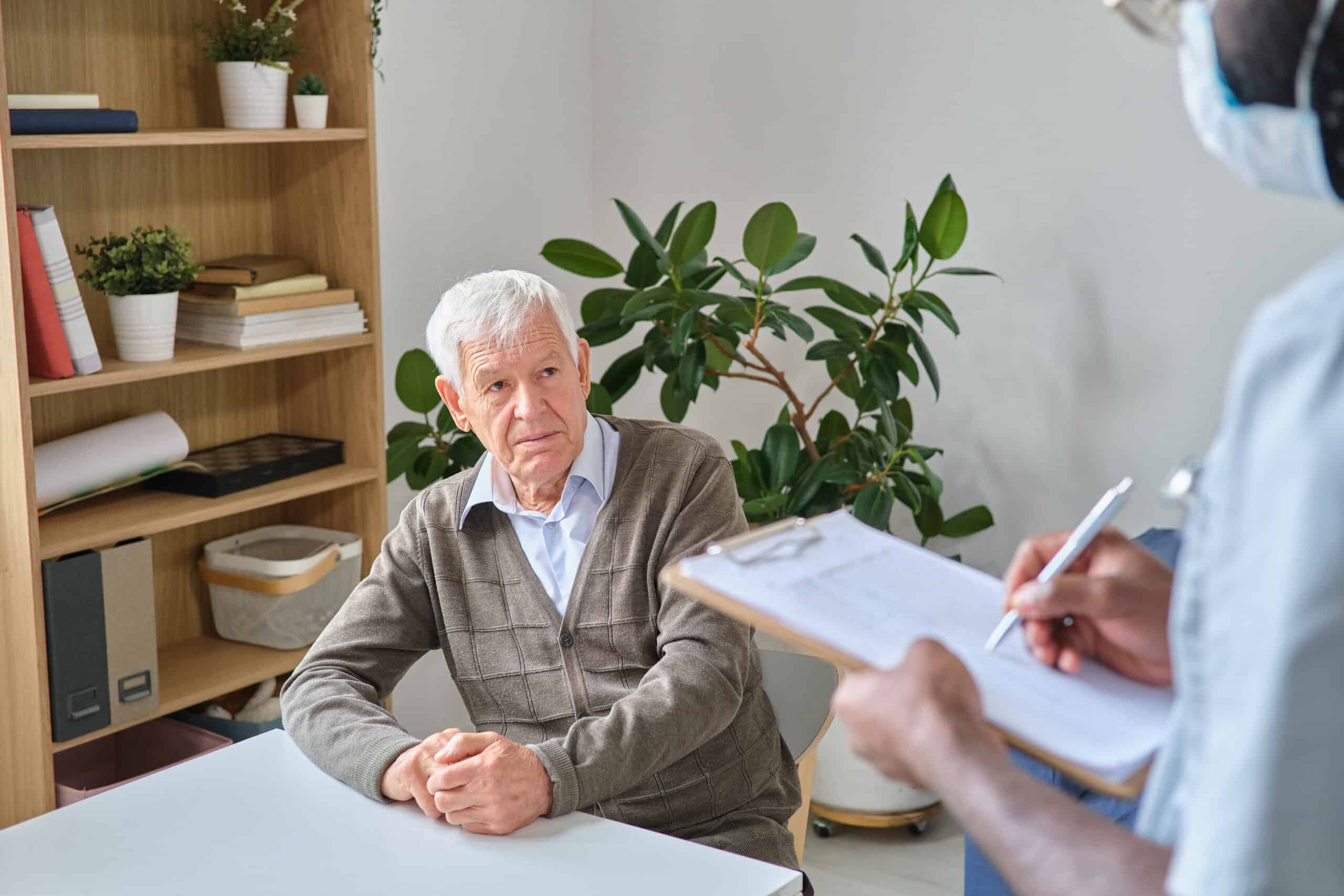 An elderly man sitting at a desk while asking a doctor does ocd get worse with age.