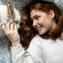 smiling woman with cat on bed